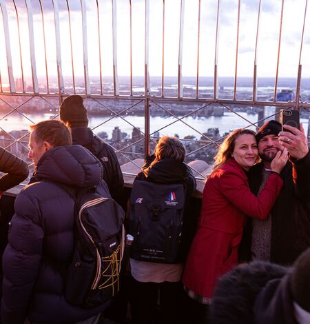 People taking a selfie with the view on the 86th Floor at the Empire State Building Observatry